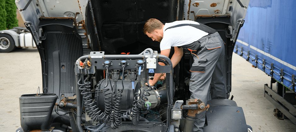A mechanic performs service on a Detroit Diesel Series 60 engine.