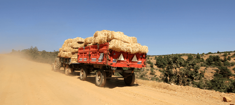A red tractor on a dusty mountain.