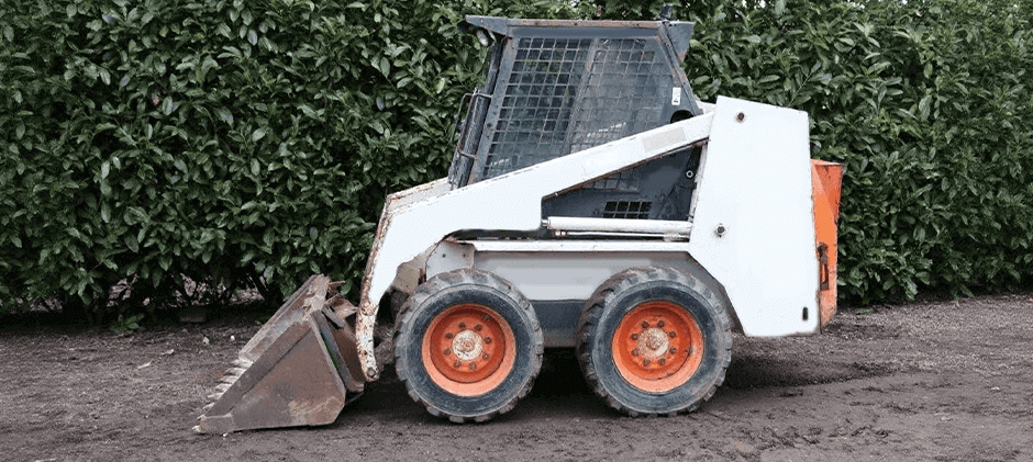Side view of a classic Bobcat 743 skid steer, a durable compact loader used on farms and job sites.