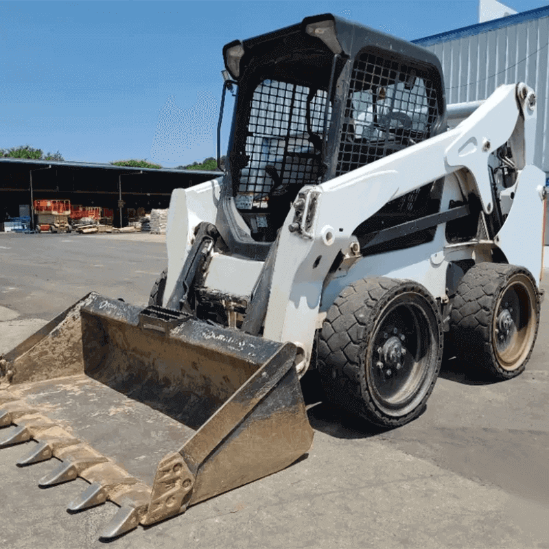 Skid Steer Loader: Built for Hard Surfaces A white skid steer with a toothed bucket attachment parked on an asphalt surface, highlighting its wheeled undercarriage.