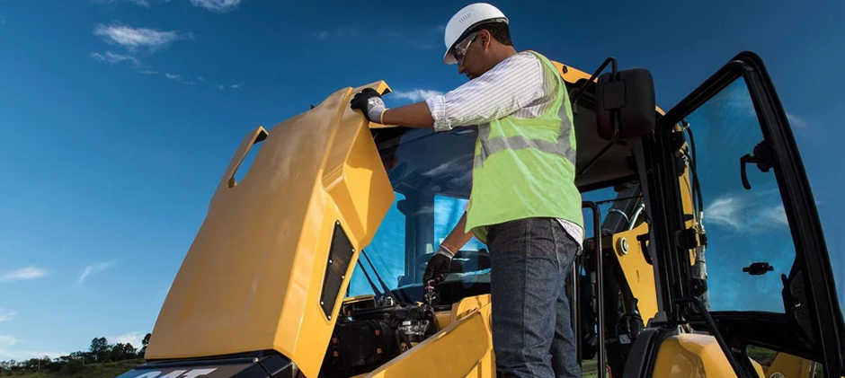 A yellow backhoe loader on a worksite, which can experience common issues like slow hydraulics or engine problems.