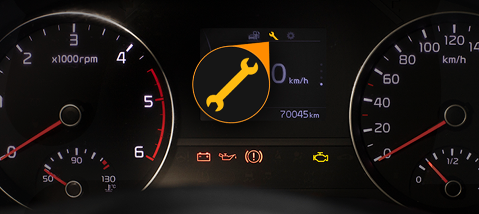 Close-up of a car dashboard displaying the wrench light and other indicators.