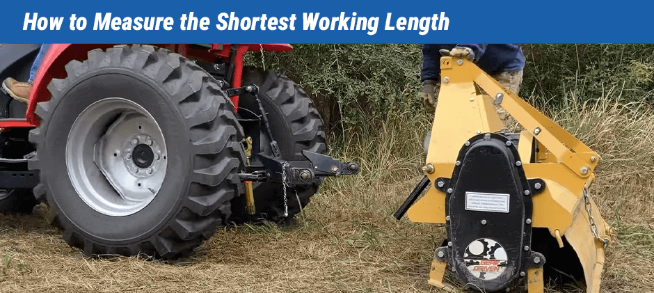 A person measuring the distance between a tractor's PTO and an implement to find the shortest working length for a PTO shaft.