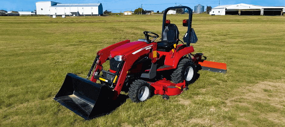 A red Massey Ferguson GC1723E tractor equipped with both a front loader and a mid-mount mower deck, sitting on a large, manicured lawn.