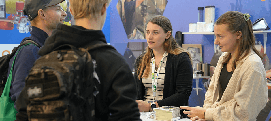 A FridayParts representative engaging in a detailed conversation with attendees at the booth during Agritechnica 2025.