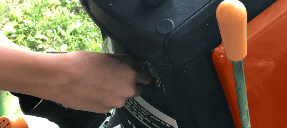 An operator inserting a key into the ignition switch on the control panel of a tractor.