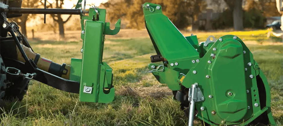 Close-up of a green Category 1 quick-hitch on a tractor, aligning with a compatible implement for easy attachment.