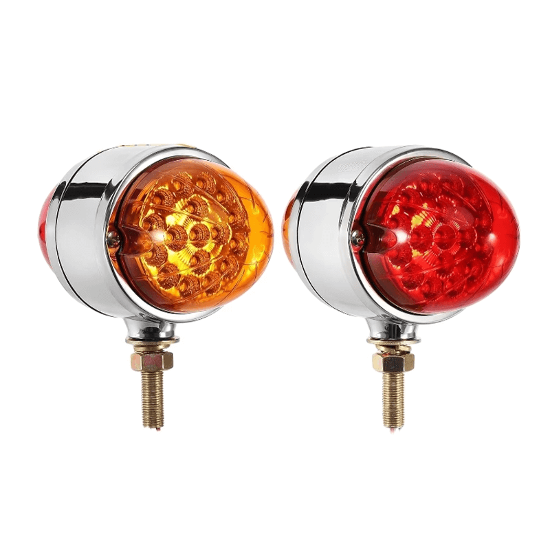 A pair of heavy-duty, round LED lights for machinery, one with an amber lens and one with a red lens, both in chrome housing.