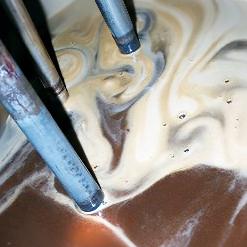 Severe Oil Contamination Leading to Foaming Severely contaminated hydraulic oil in a reservoir, showing a milky, swirling mixture of oil and water.