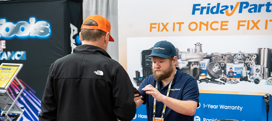 A FridayParts team member provides on-the-spot support to a visitor at The ARA Show booth, looking up information to help identify the correct equipment part.