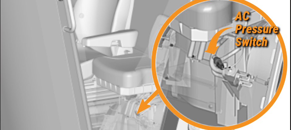 Diagram showing the location of an AC pressure switch inside the cab area of a piece of heavy machinery.
