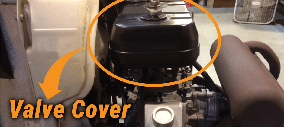 A close-up of a black valve cover on a small utility engine, circled to show its location on top of the engine block.