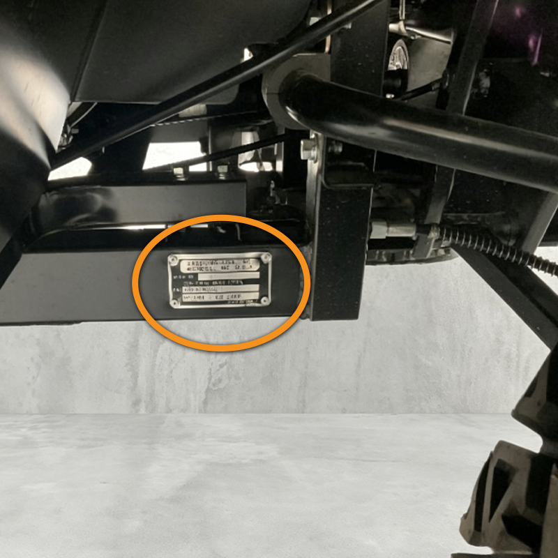 A close-up view of a metal Kioti identification plate riveted to the frame of a piece of UTV.
