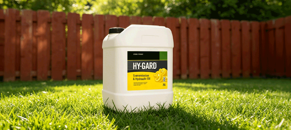 A white jug of John Deere Hy-Gard transmission and hydraulic oil sitting in a lush green lawn.