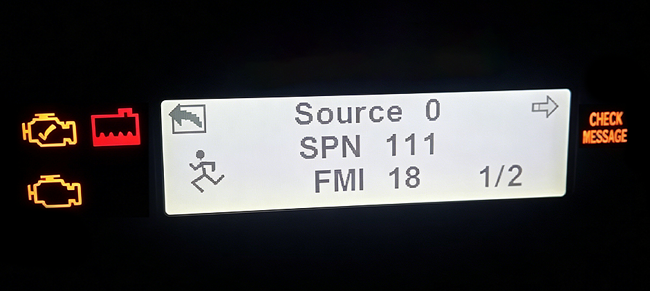 A close-up of a heavy equipment digital dashboard displaying the fault code SPN 111 FMI 18 with check engine lights on.