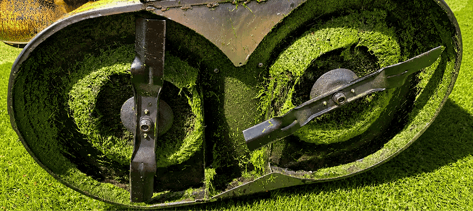 The underside of a two-blade mower deck showing the blades correctly installed on their spindles.