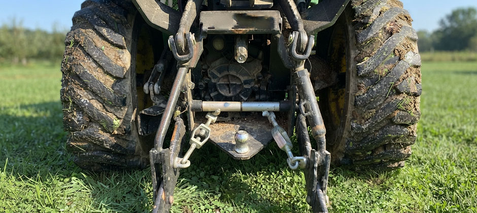 Full rear view showing lower lift arms, hitch pins and rear tires — useful to check pin play and tire clearance.