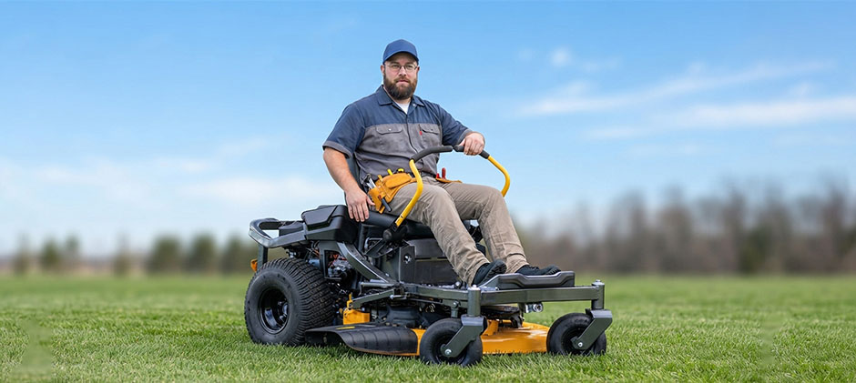 Side/front-side view of operator on a Cub Cadet zero‑turn mower showing lap bars, deck and front casters.