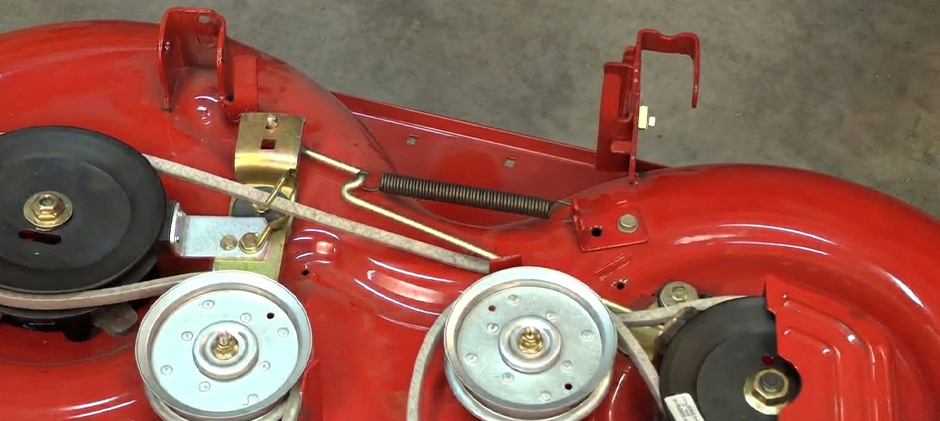 Belt tension idler spring installed on a red Troy-Bilt Pony mower deck.