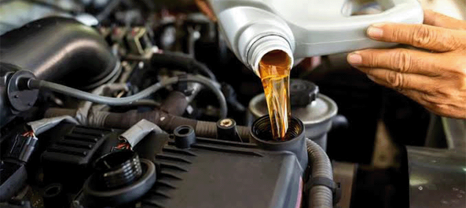 Close-up of pouring diesel engine oil into a heavy-duty truck engine.