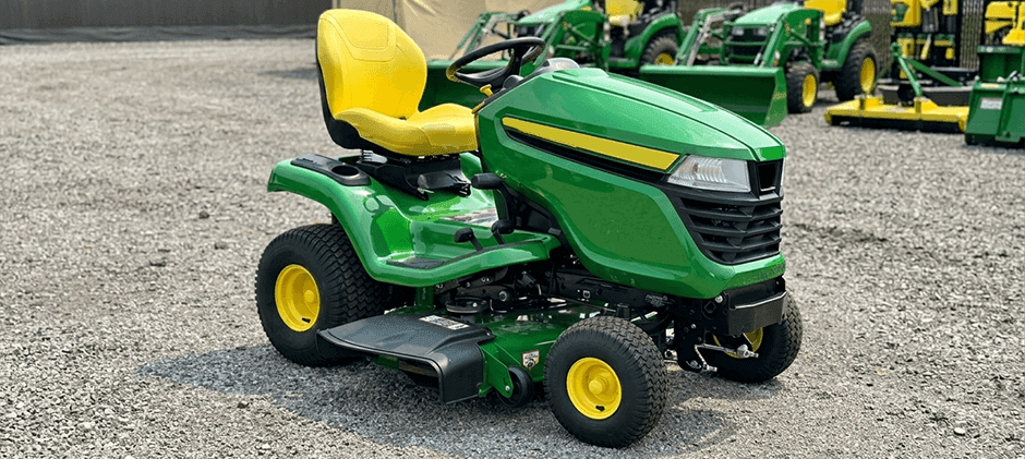 John Deere X370 lawn tractor parked on a gravel lot.